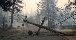 Photo of downed PG&E power lines against a smokey background